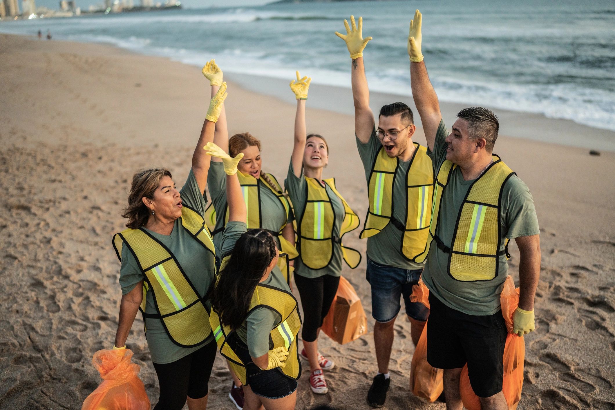 Volunteers celebrating outdoors with arms raised