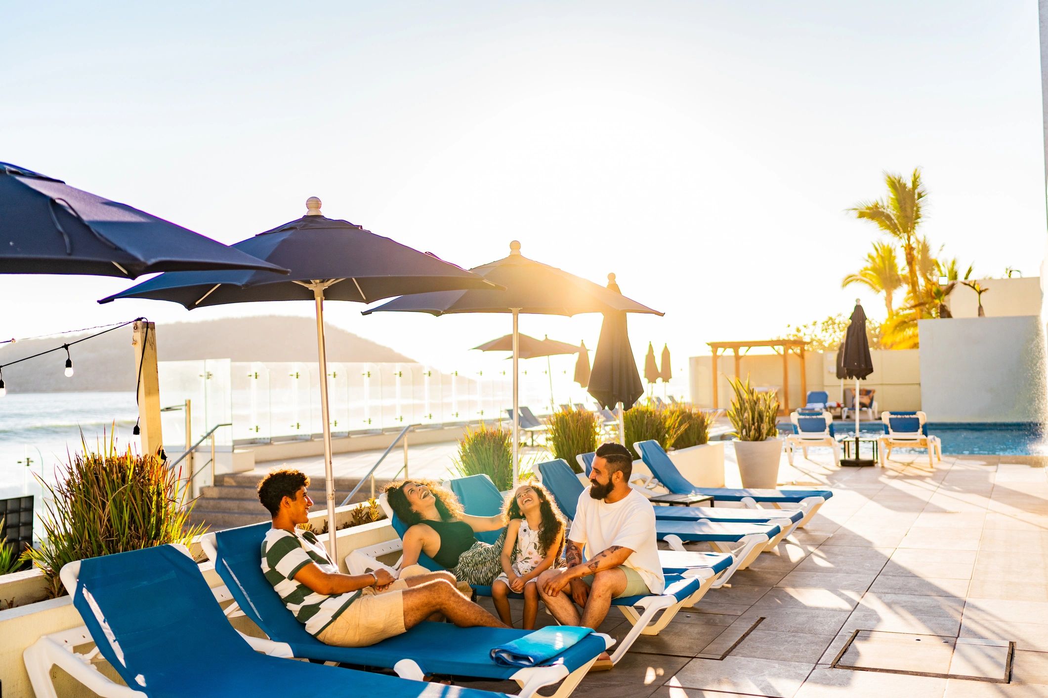 People talking at a waterfront resort setting (illustrative of Subic Bay club community)